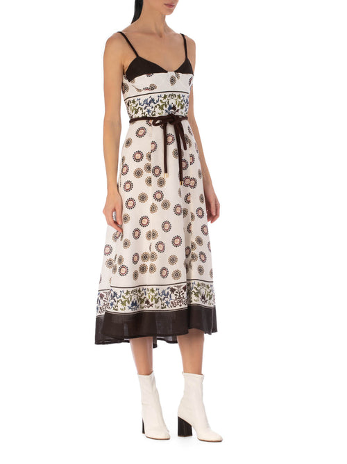 A sleeveless summer Dalil Dress Multi Sepia Floral midi dress with a ribbon tie around the waist, isolated on a white background.