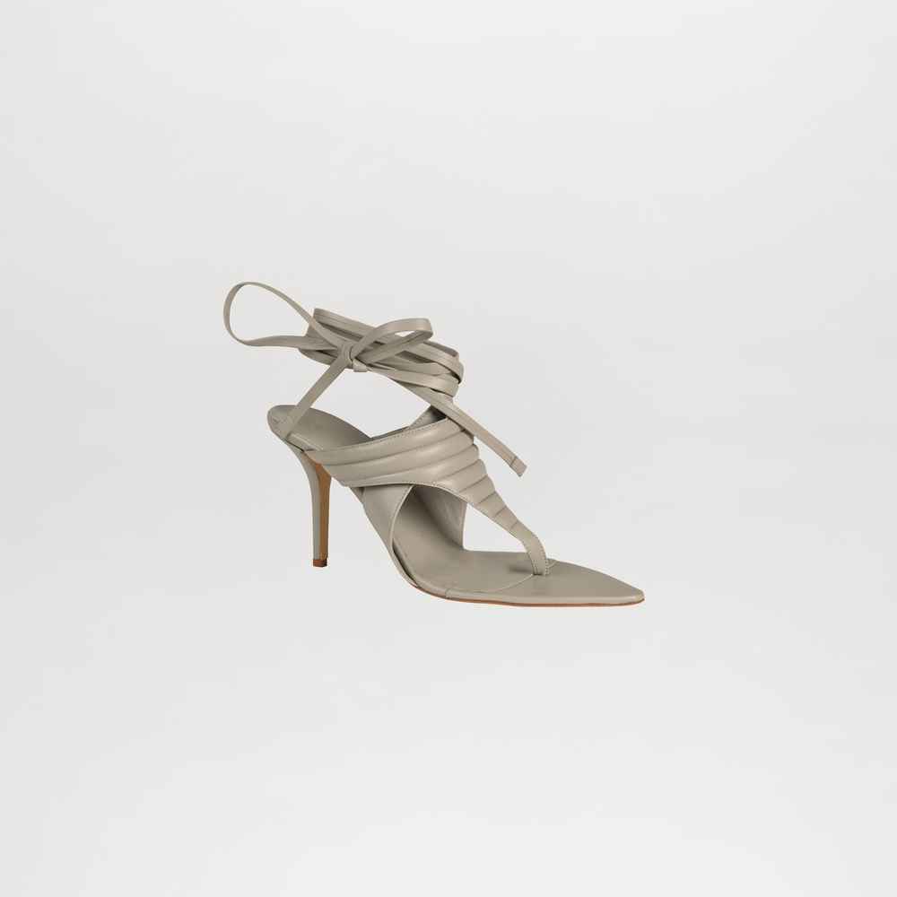 Beige high-heeled sandal with strappy design on a light gray background