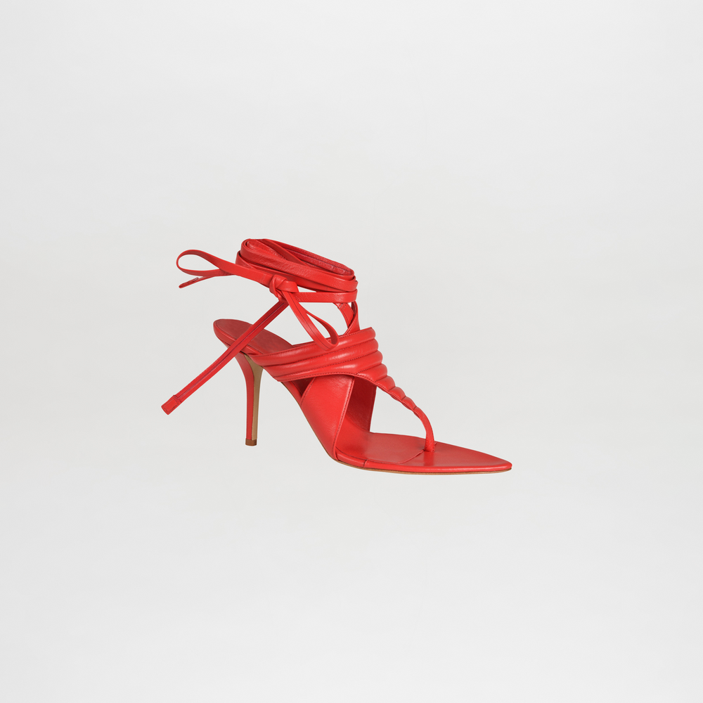 Red high-heeled sandal on a light gray background