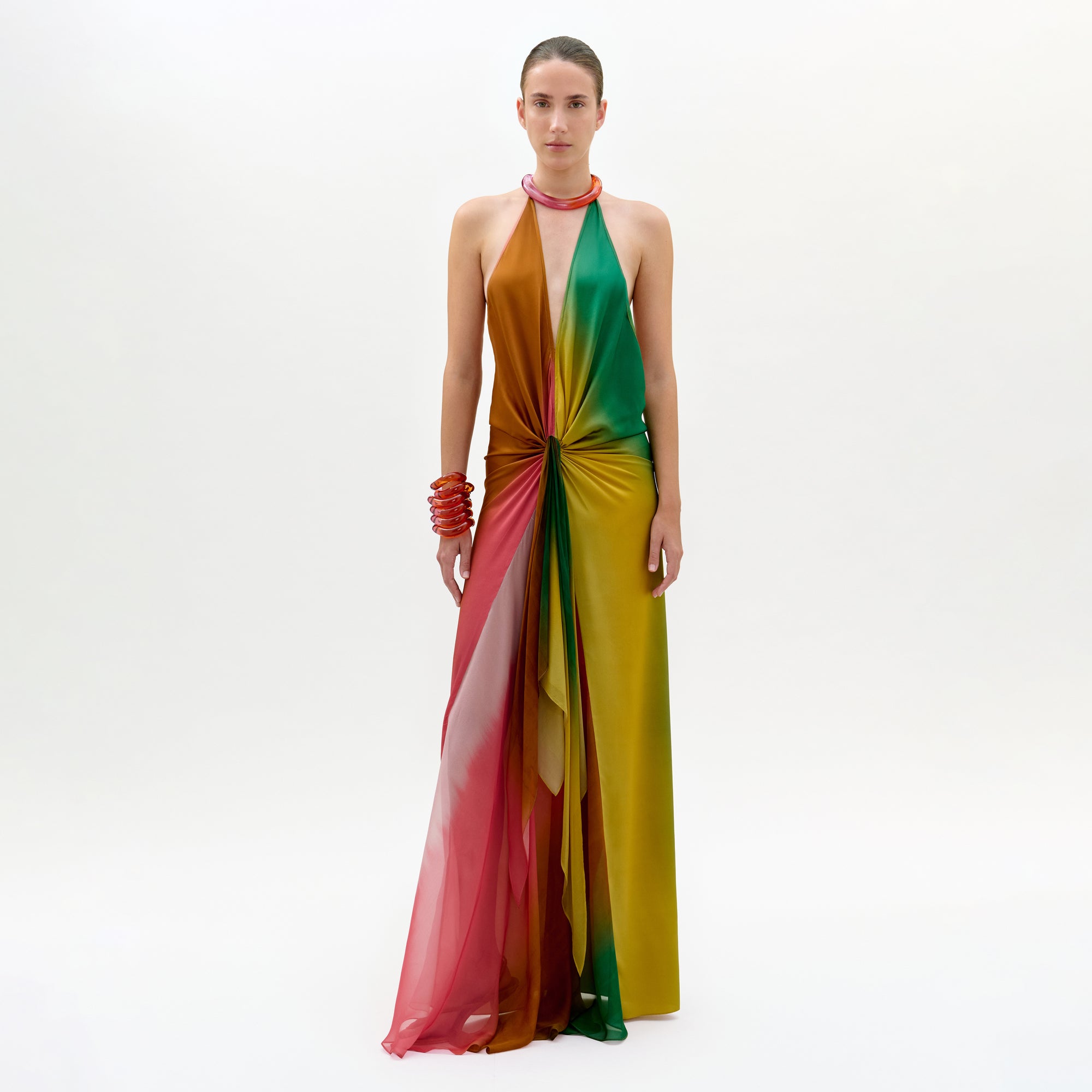 Model wearing a colorful halter neck dress on a white background