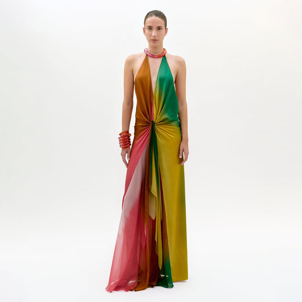 Model wearing a colorful halter neck dress on a white background