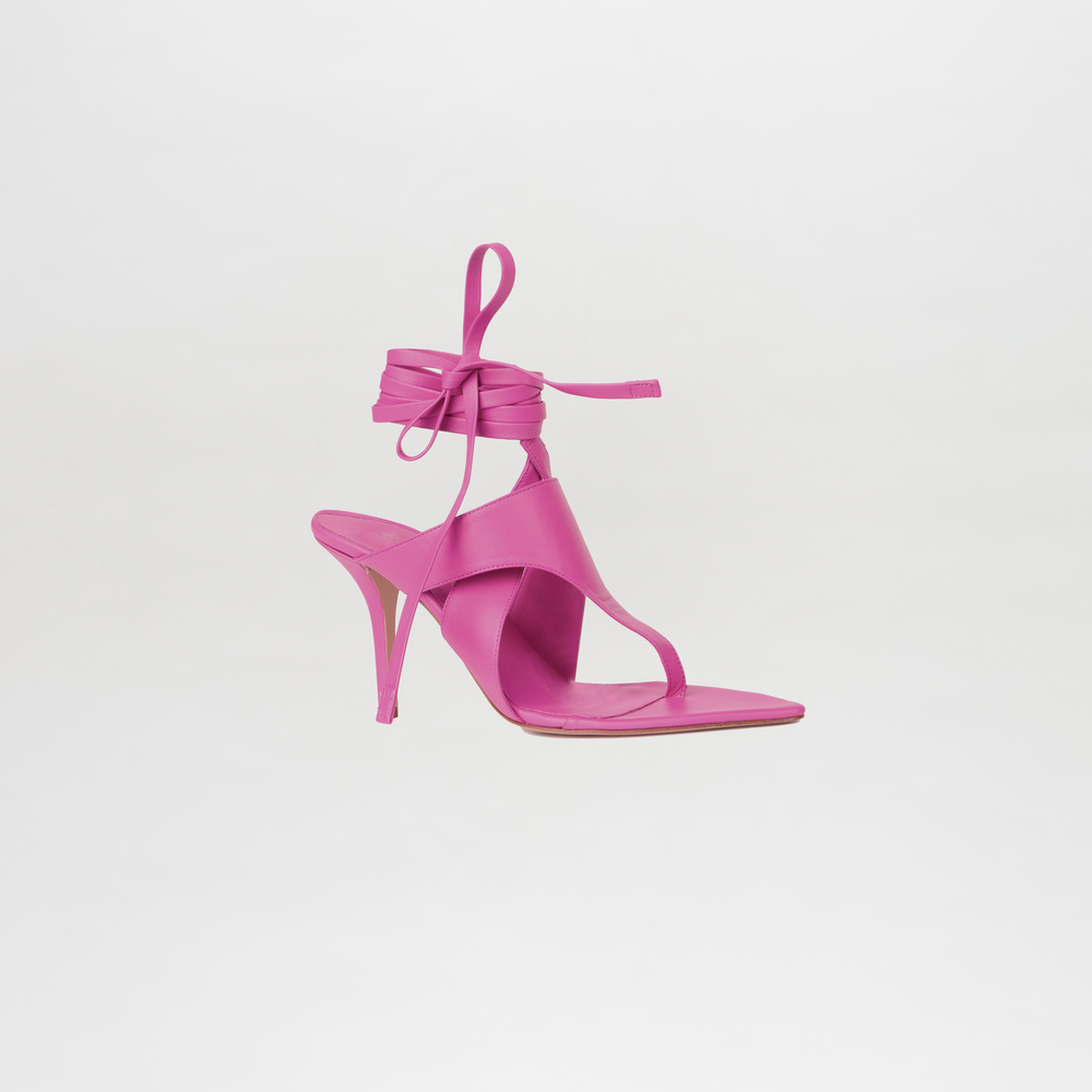 Pink high-heeled sandal with ankle strap on a light gray background