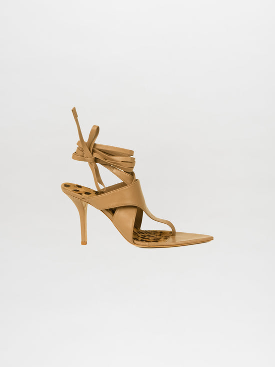 The Domenico Heels Taupe, a high-heeled sandal made from Italian leather with ankle wrap straps and a slender stiletto heel, is showcased against a plain white background.