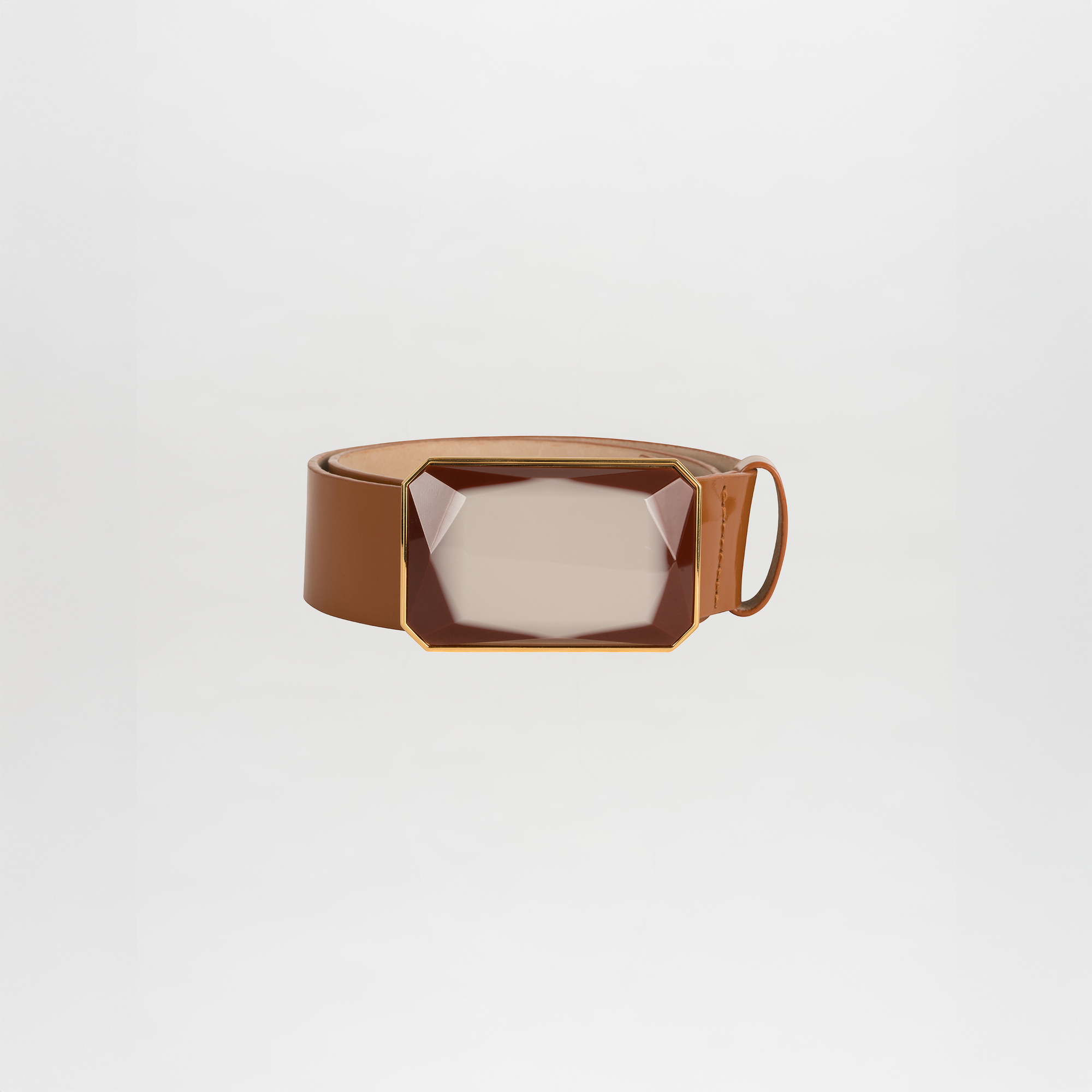 The Dora Belt is a brown leather belt with a large geometric translucent buckle featuring gold accents, shown on a plain white background.
