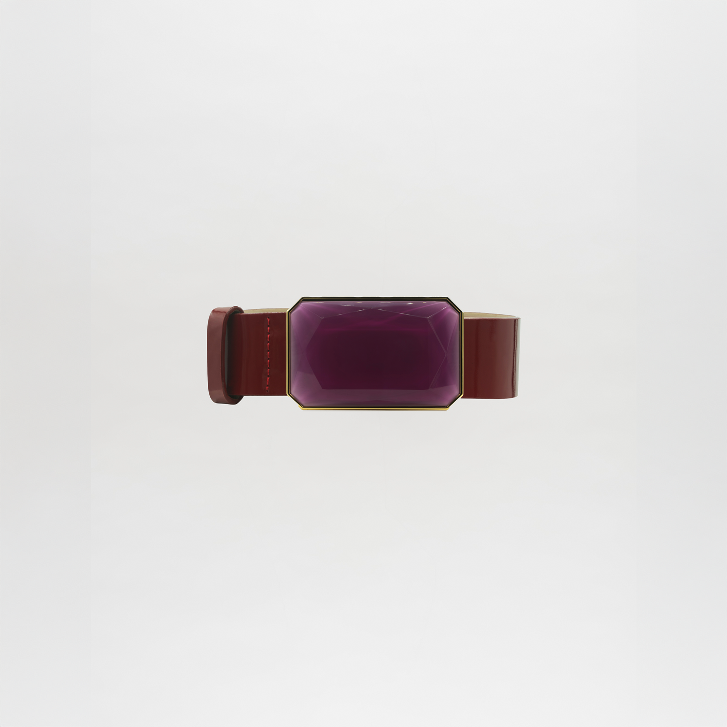 The Dora Belt features a wide brown band with a large, faceted rectangular purple gem at the center. Please allow standard processing and shipping time for delivery. Shown against a plain white background.