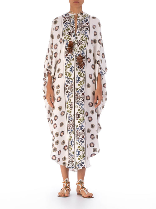 A long, white Elea Tunic Multi Sepia Floral with a mixed pattern of floral and circular designs, displayed on a transparent mannequin against a white background.