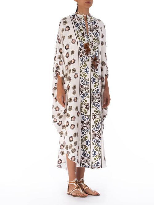 A long, white Elea Tunic Multi Sepia Floral with a mixed pattern of floral and circular designs, displayed on a transparent mannequin against a white background.