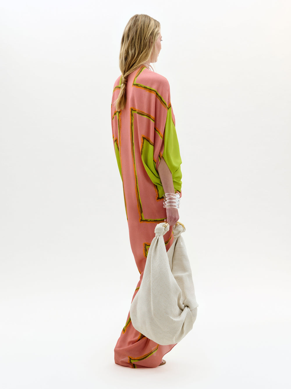 Woman wearing a colorful dress with abstract patterns on a white background