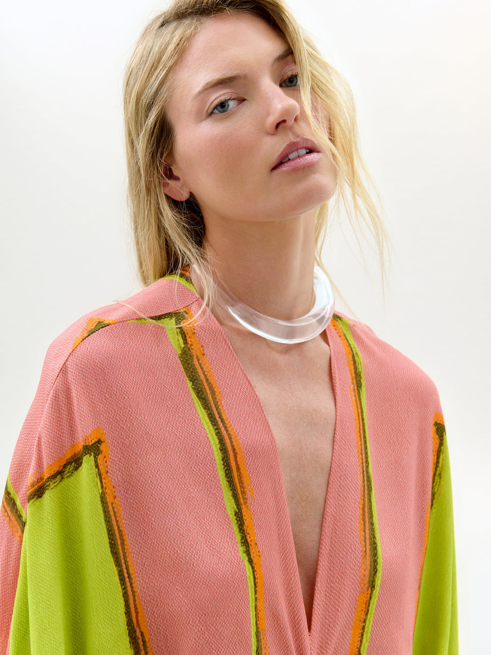 Woman wearing a colorful kimono-style garment with a plain background