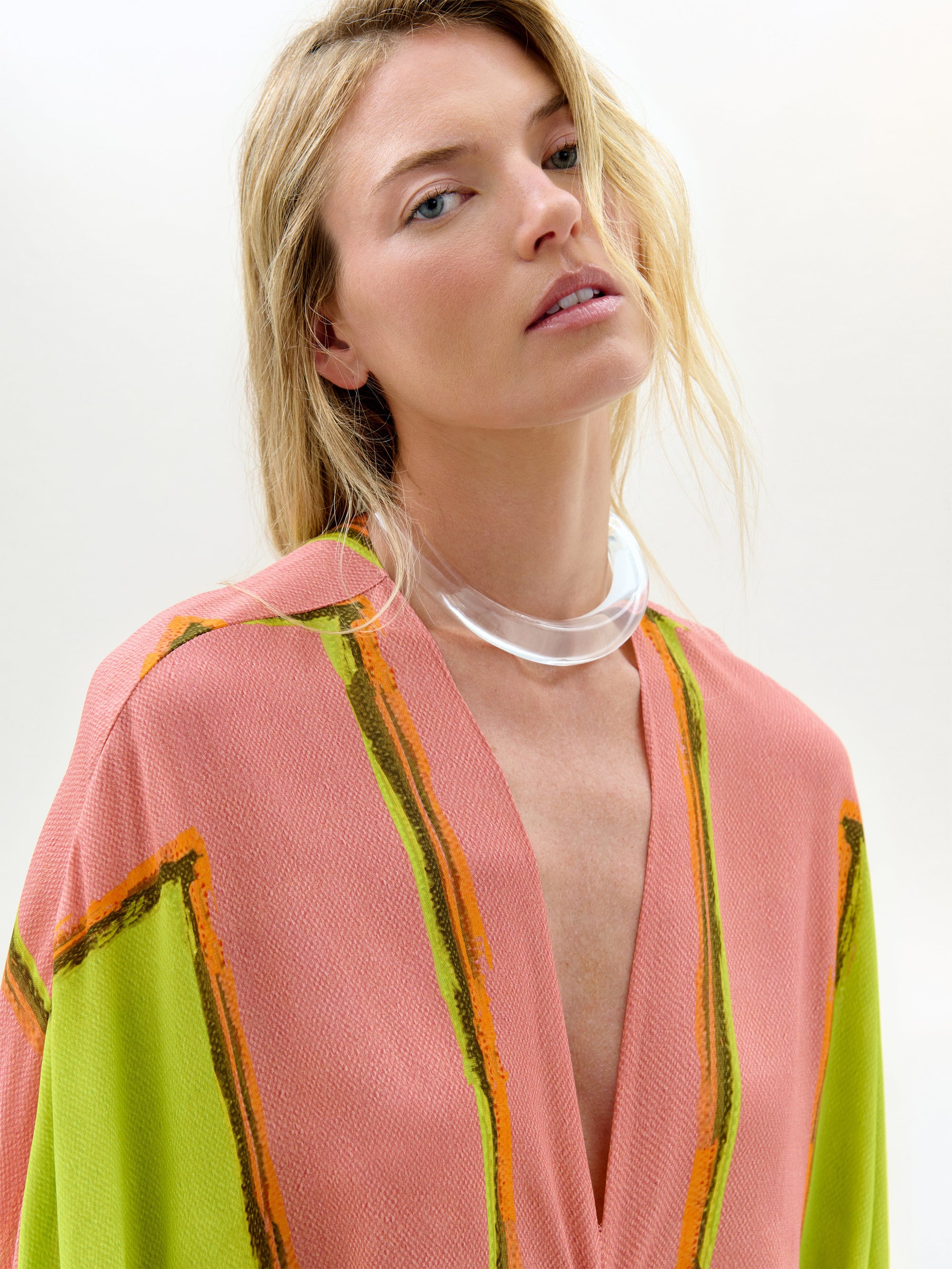 Woman wearing a colorful kimono-style garment with a plain background