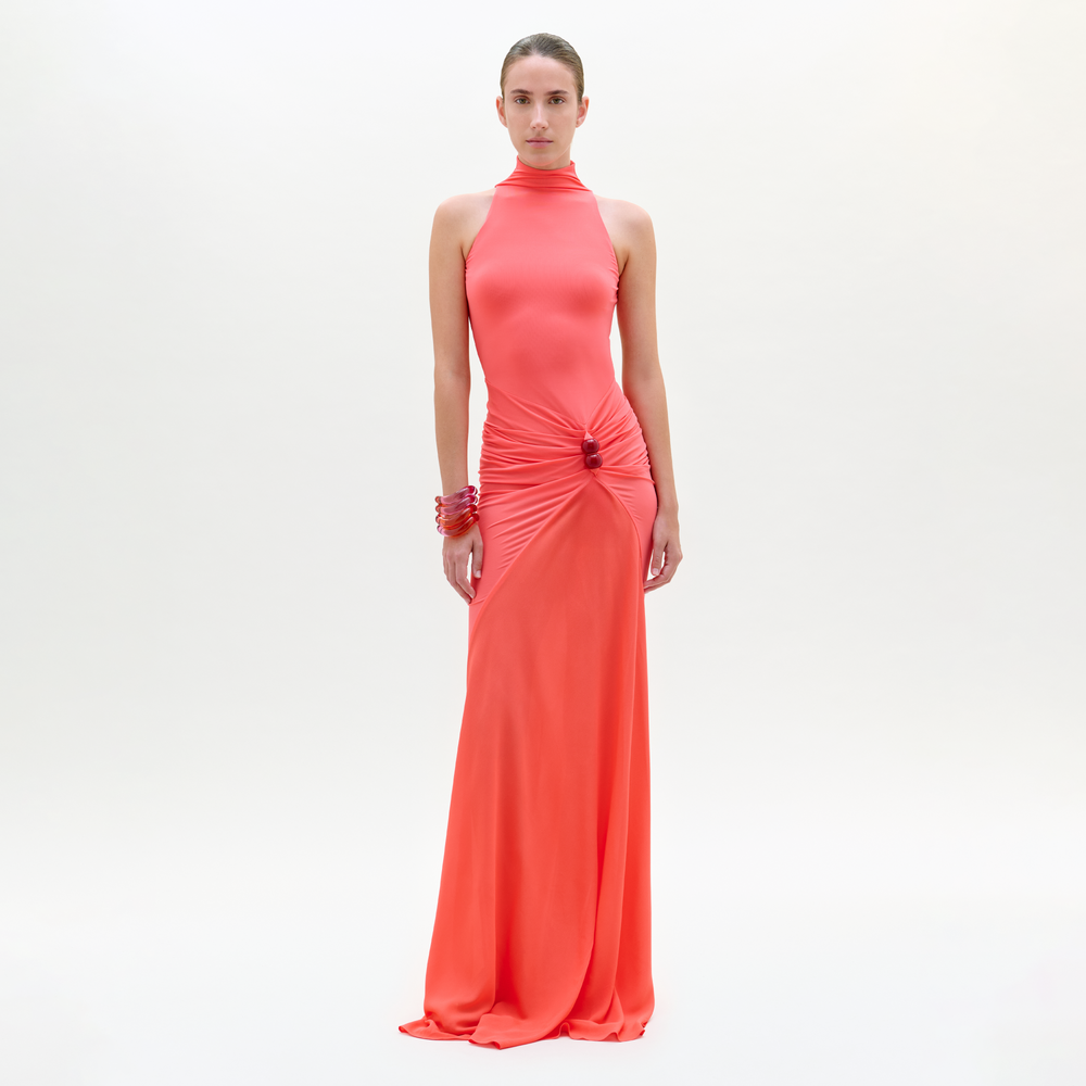 Woman wearing a coral evening gown on a white background