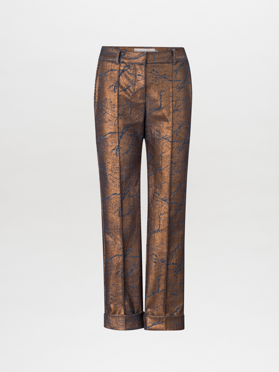 The Garmet Pant Metallic features a copper-colored pattern with a straight leg silhouette and a mid-rise cropped design. It includes cuffed hems and has a subtle metallic sheen, showcased against a plain white background.