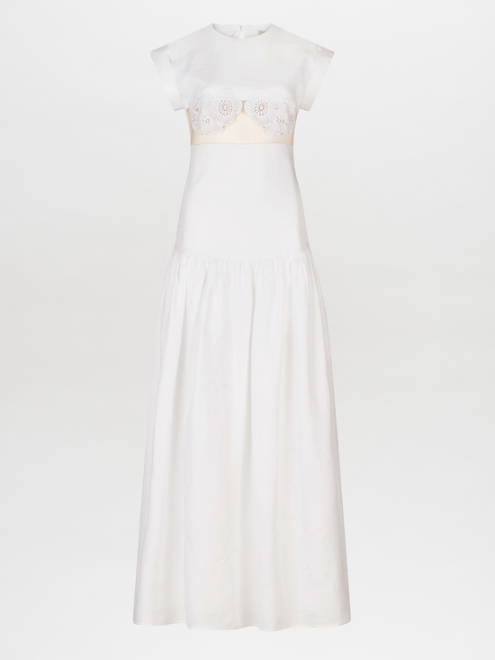 A Hanane Dress White with lace trim and a fitted silhouette.