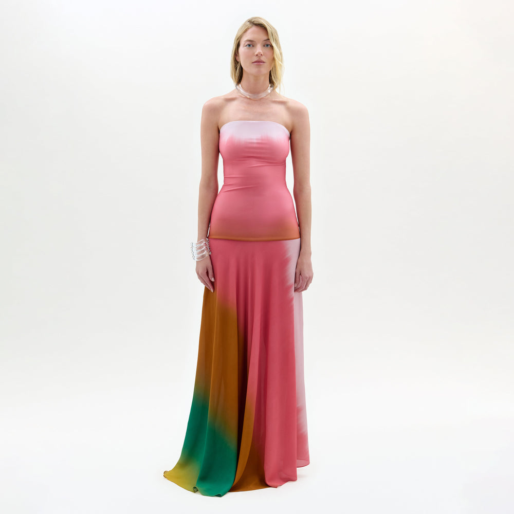 Woman wearing a strapless, multicolored dress with a white background