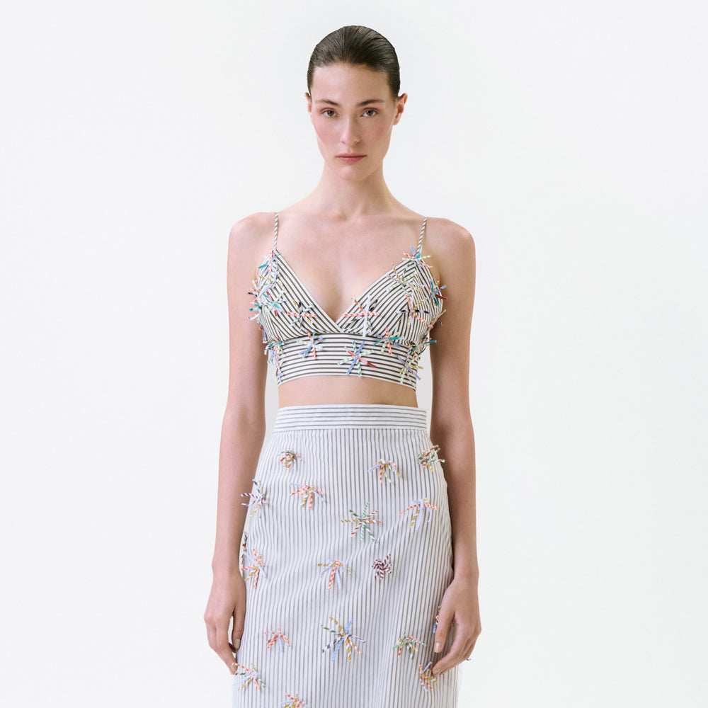 The Ibbie Top is a cropped, striped camisole featuring small, colorful fringe accents across the bodice.