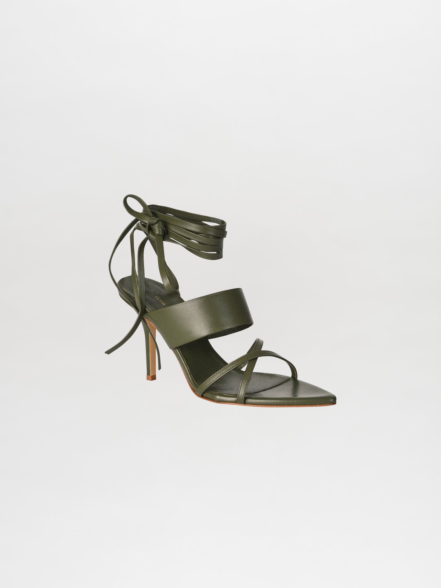 The Jimena Heels Olive is a single high-heeled sandal in olive green, meticulously crafted from Italian calf leather. It features multiple straps and a wraparound ankle tie, showcasing the elegant design from the Gia Borghini collaboration.