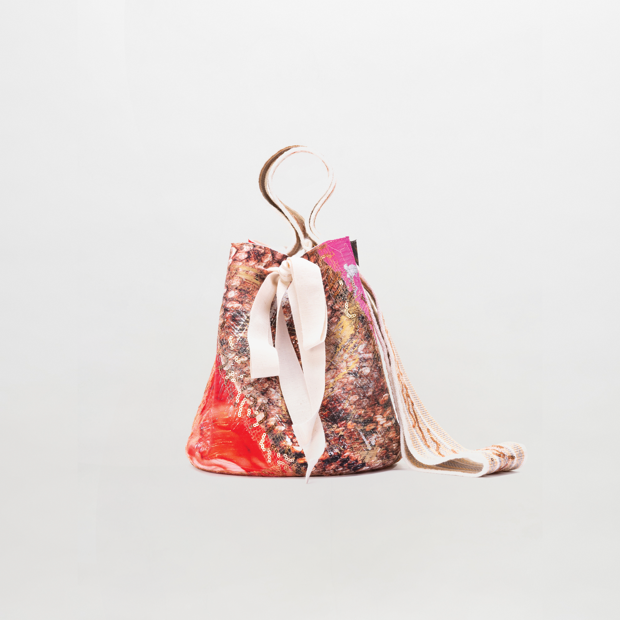 Drawstring bag with colorful pattern and ribbon on a light gray background