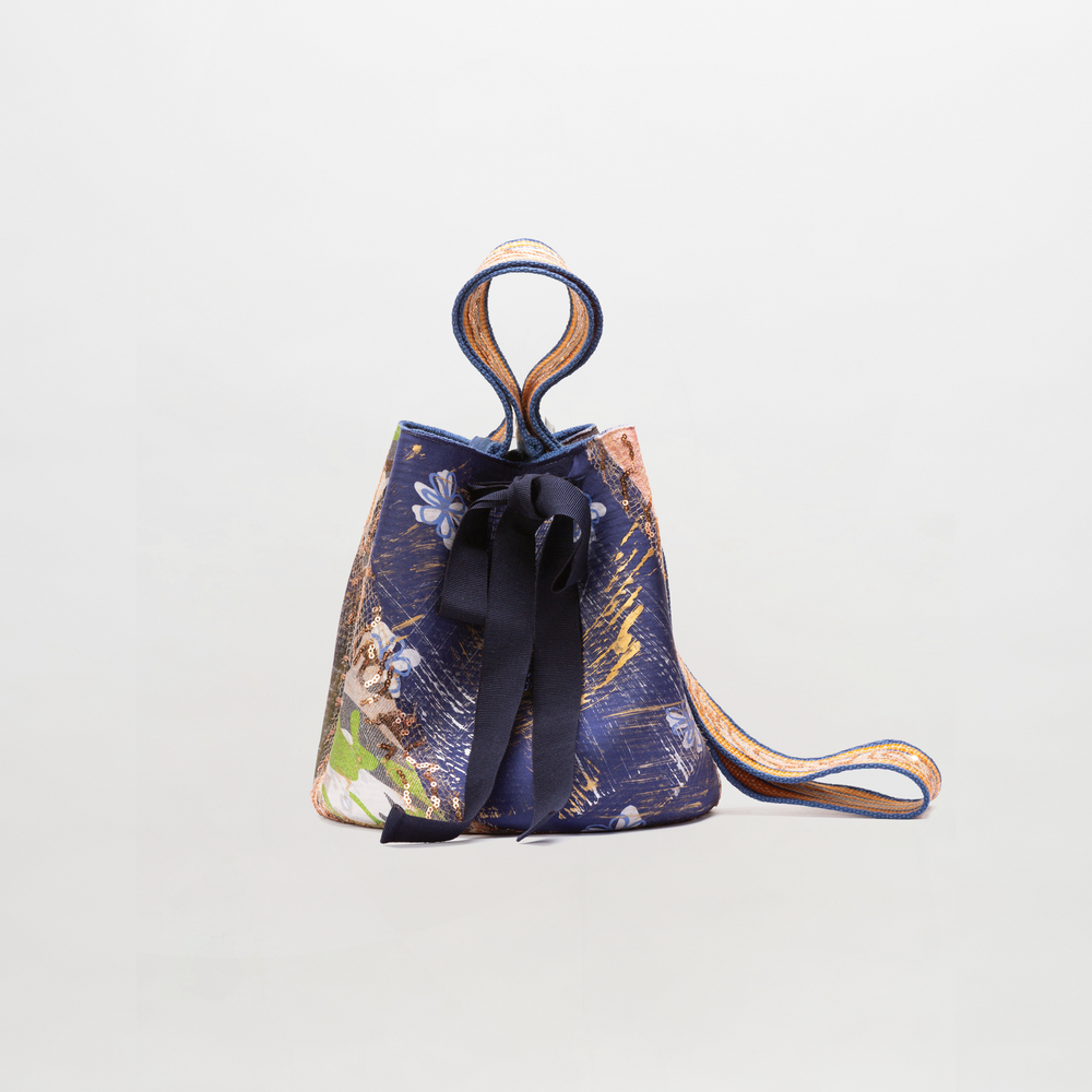 Small drawstring bag with floral pattern and black ribbon on a light gray background