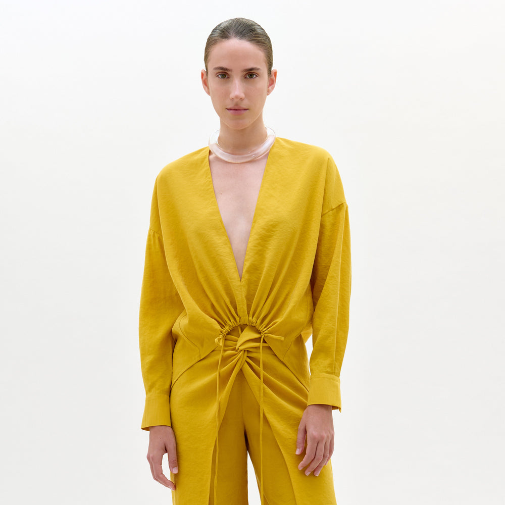 Woman wearing a yellow jumpsuit on a white background