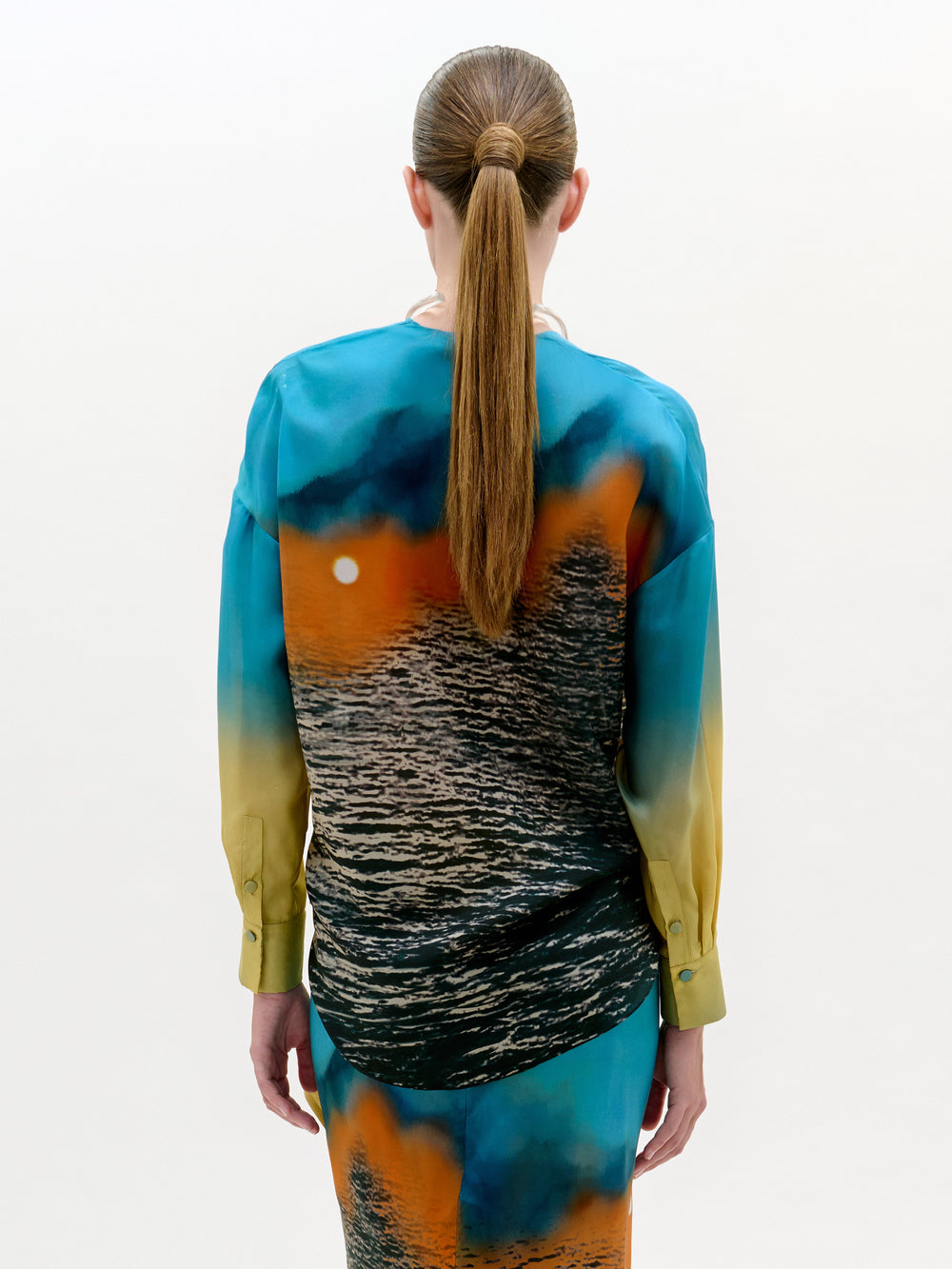 Person wearing a colorful dress with a gradient design on a white background
