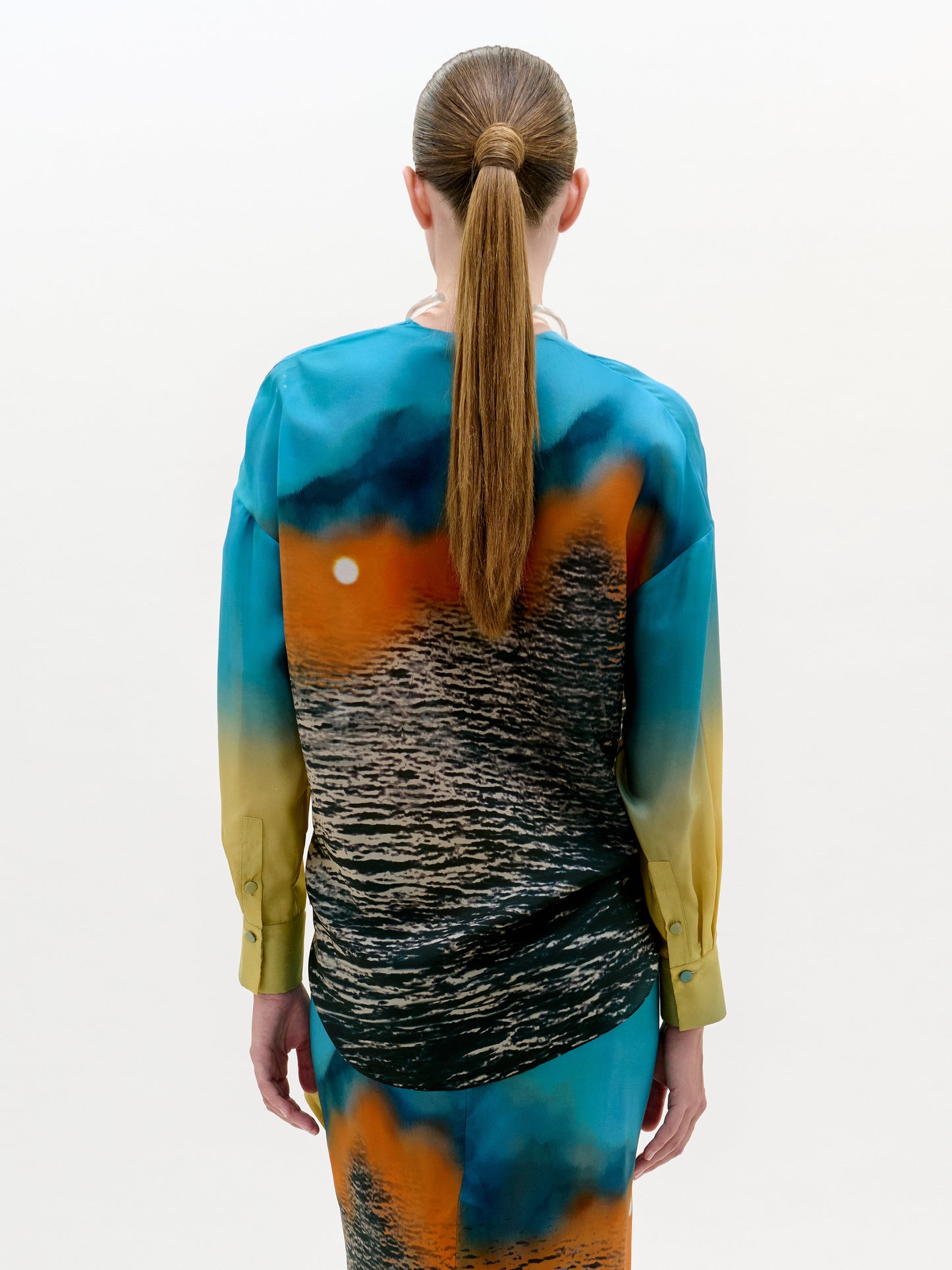 Person wearing a colorful dress with a gradient design on a white background