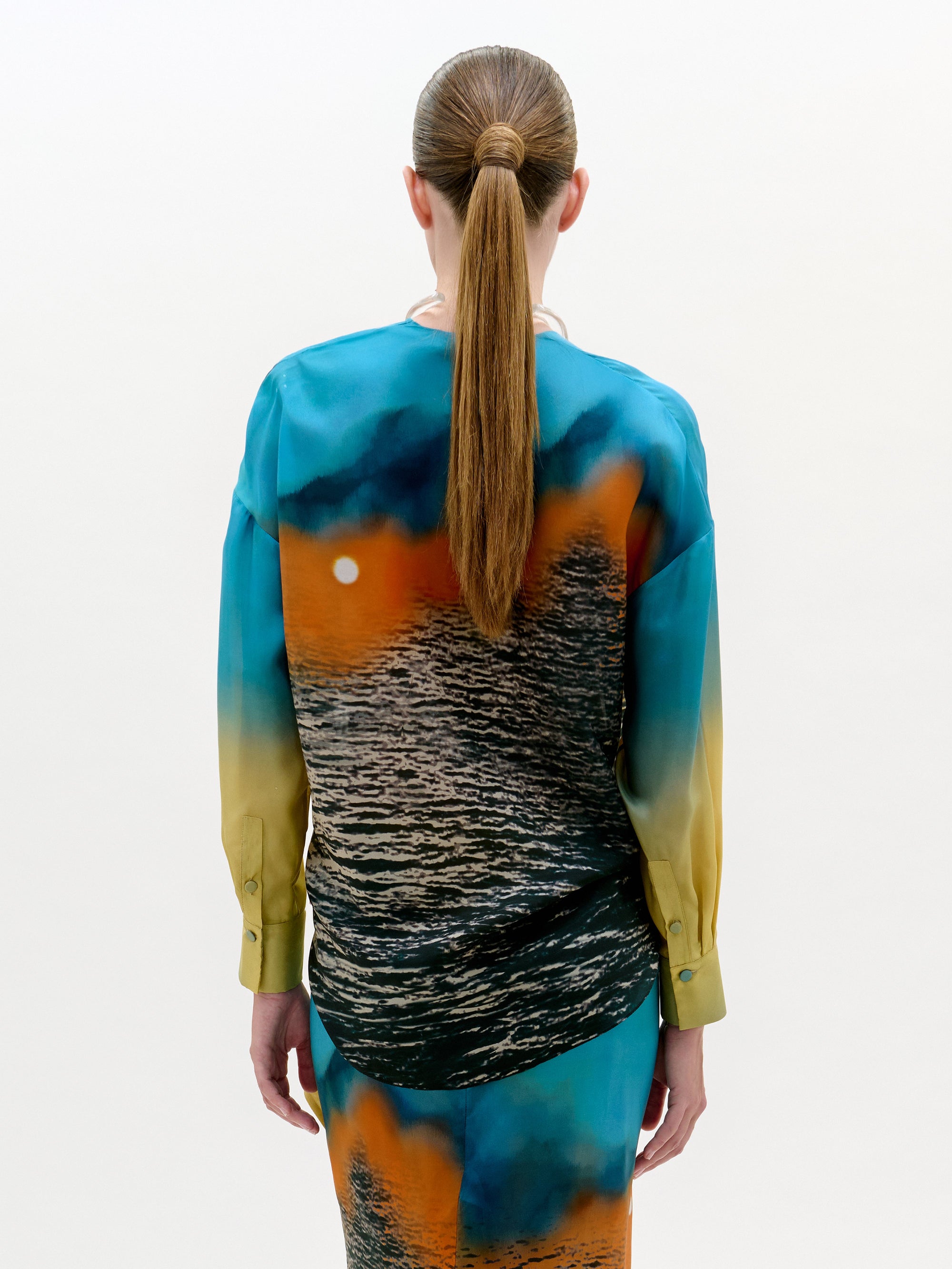 Person wearing a colorful dress with a gradient design on a white background