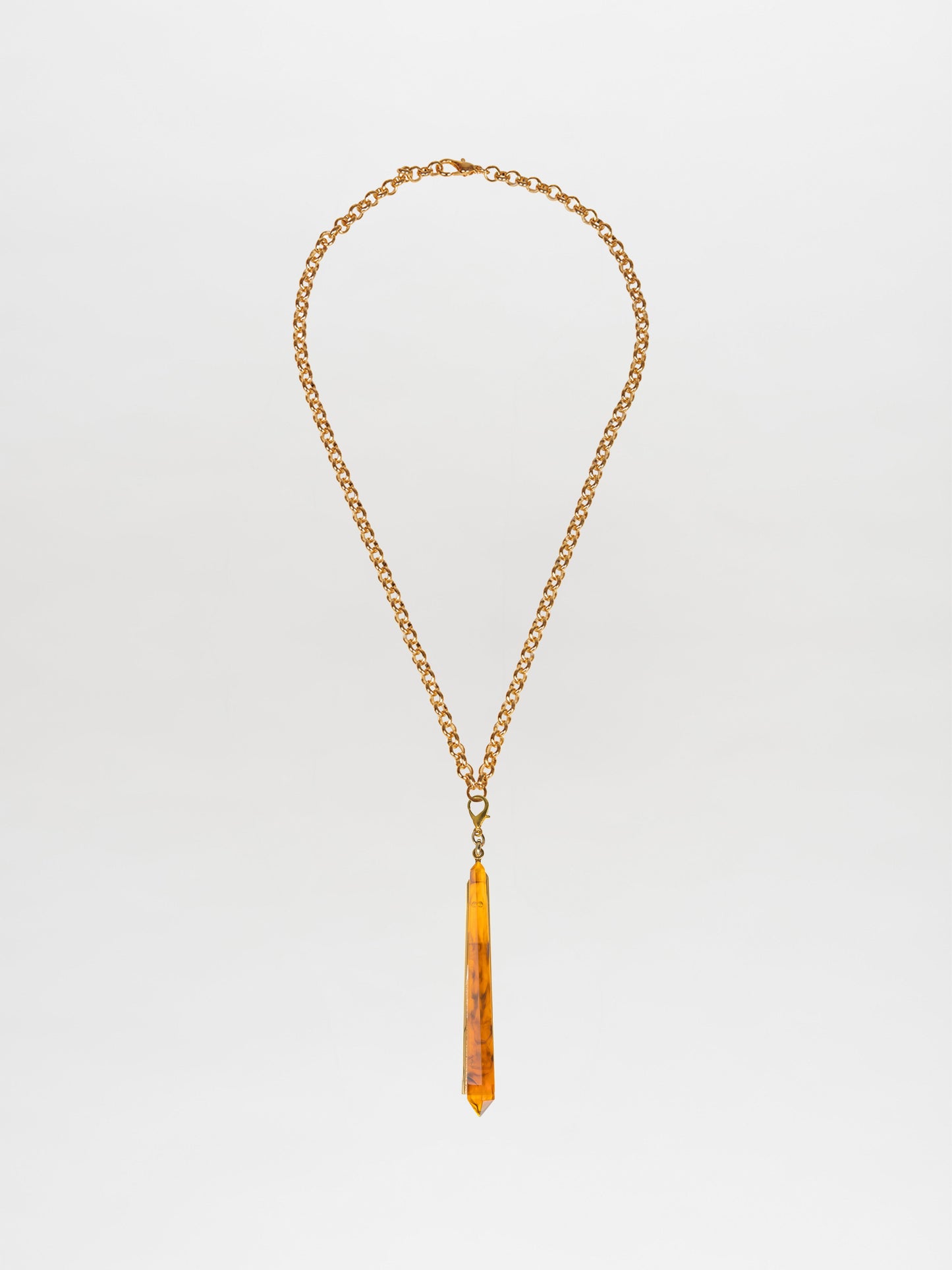 Introducing the Montse Necklace Amber: a stunning gold-plated brass chain with a long, narrow amber pendant that adds an elegant touch to any outfit. Perfect for layering or wearing solo as a minimalist statement piece.