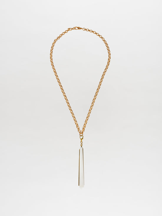 The Montse Necklace Pearl, a gold chain necklace with a long, pointed geometric crystal pendant on a white background, embodies the elegance of a Tcherassi design.