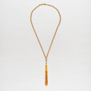 The Montse Necklace is a gold chain layering piece featuring a geometric amber crystal pendant, elegantly centered and crafted in Italy, shown against a plain white background.