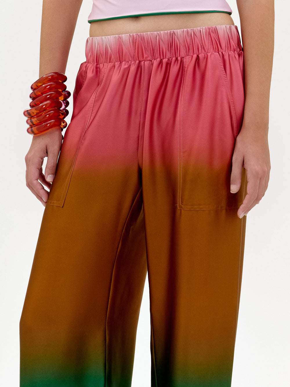 Gradient pants transitioning from pink to orange with a white background