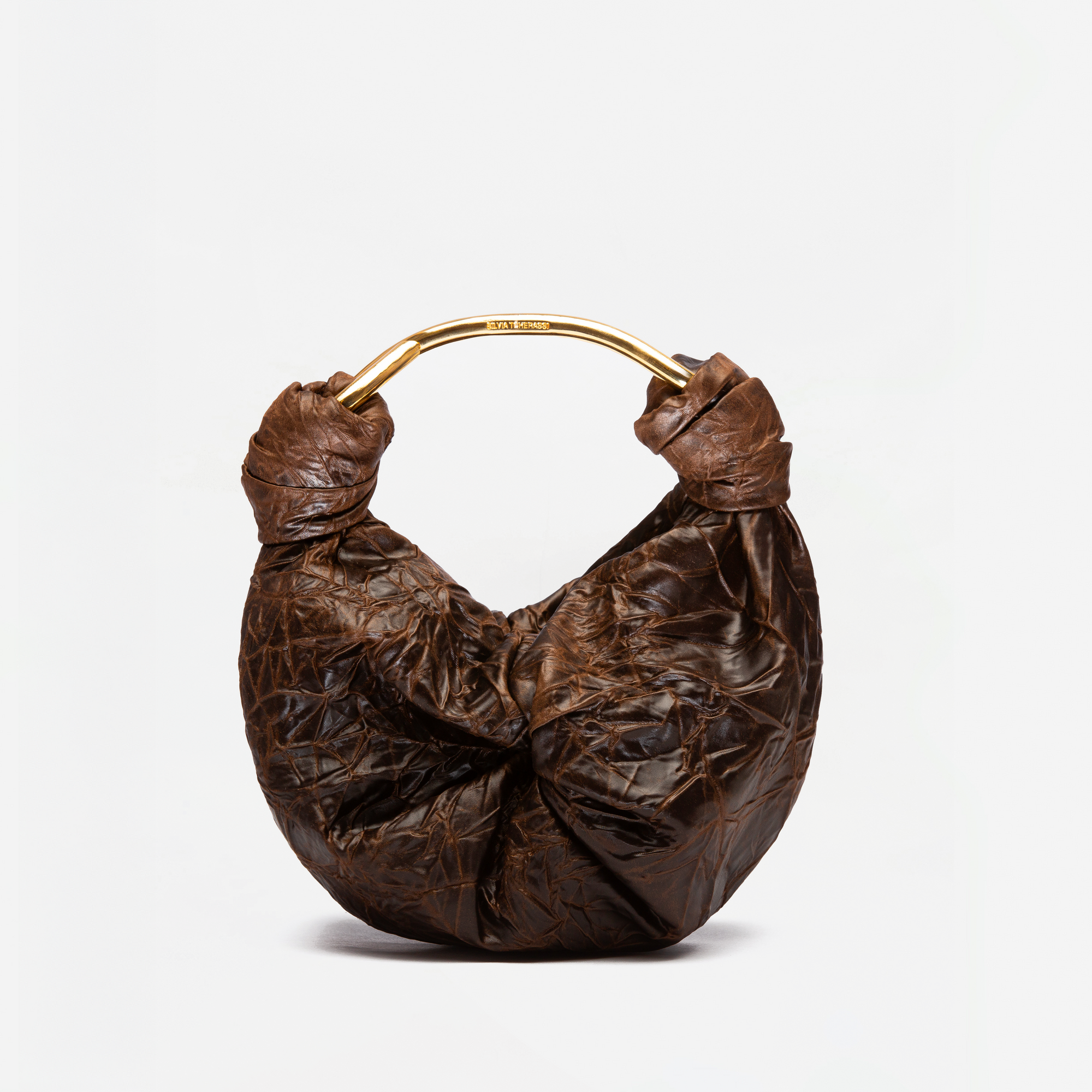 The Sofia Bag (Small) is a brown, crescent-shaped bag with a crinkled texture and gold-toned handle, crafted from premium Italian fabric, shown against a plain white background.