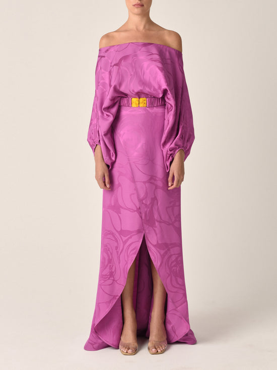 A Meggie Dress Magenta Orchid Jacquard, off-the-shoulder dress with a floral print and yellow belt.
