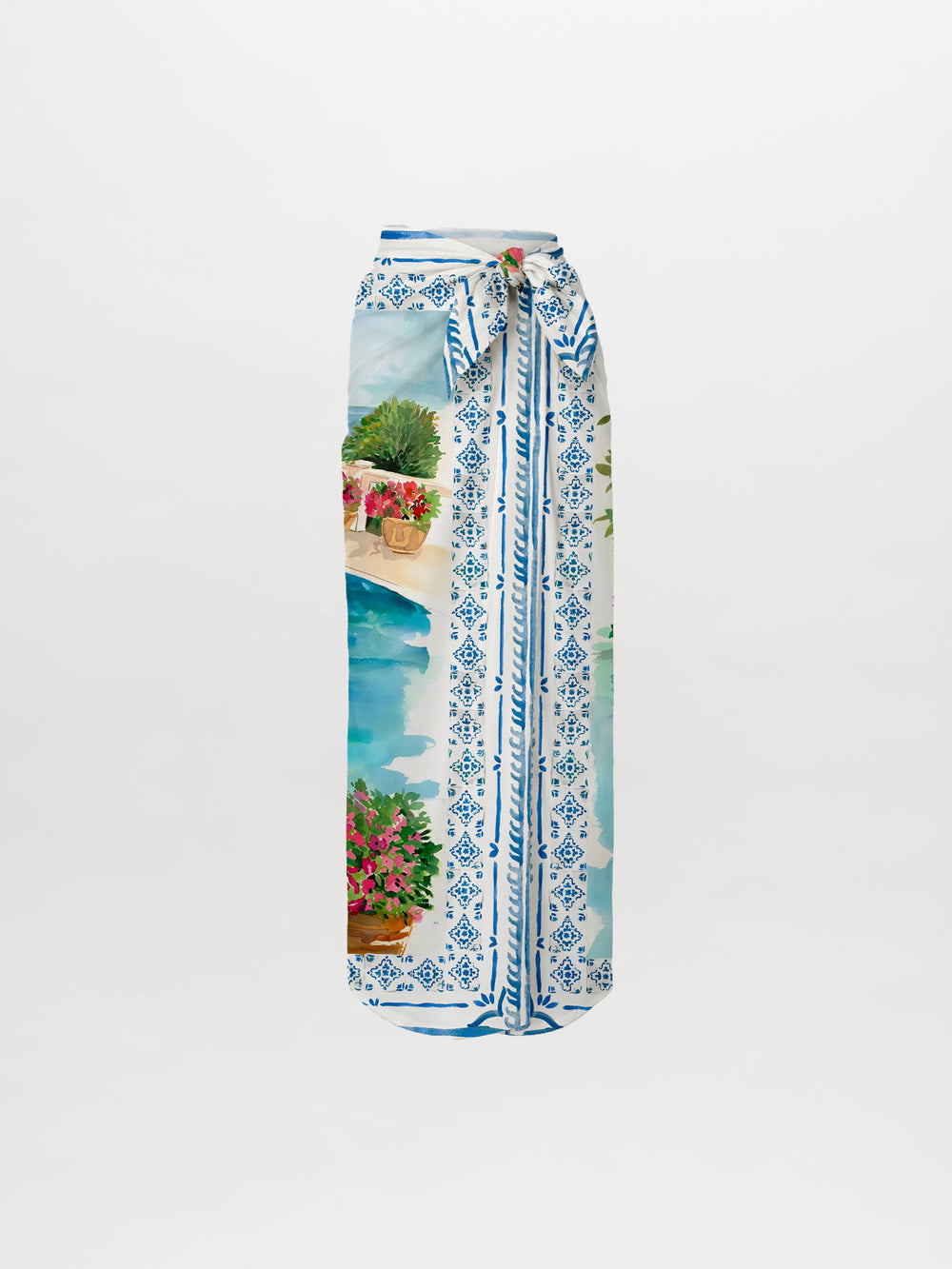 The La Isla Skirt Pareo is a long, high-waisted skirt with a blue and white geometric pattern and watercolor poolside scene, featuring potted flowers, greenery, a stone wall, and a matching waist tie belt.