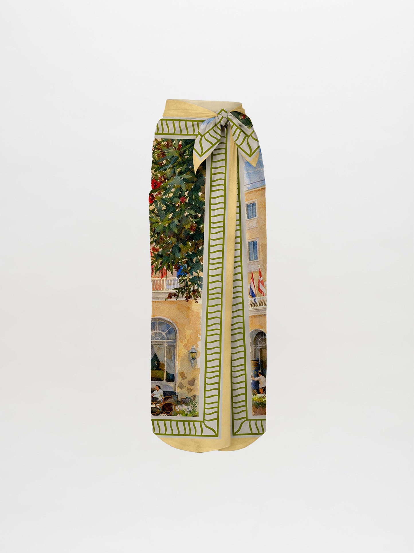 The La Isla Skirt Pareo is a midi wrap skirt with a knotted waist tie, showcasing a printed scene of buildings, trees, and people. It’s bordered by a green and cream geometric pattern and displayed on a white background.