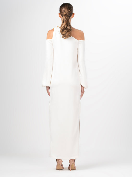 A Ada Dress White with a metallic gold shoulder detail.