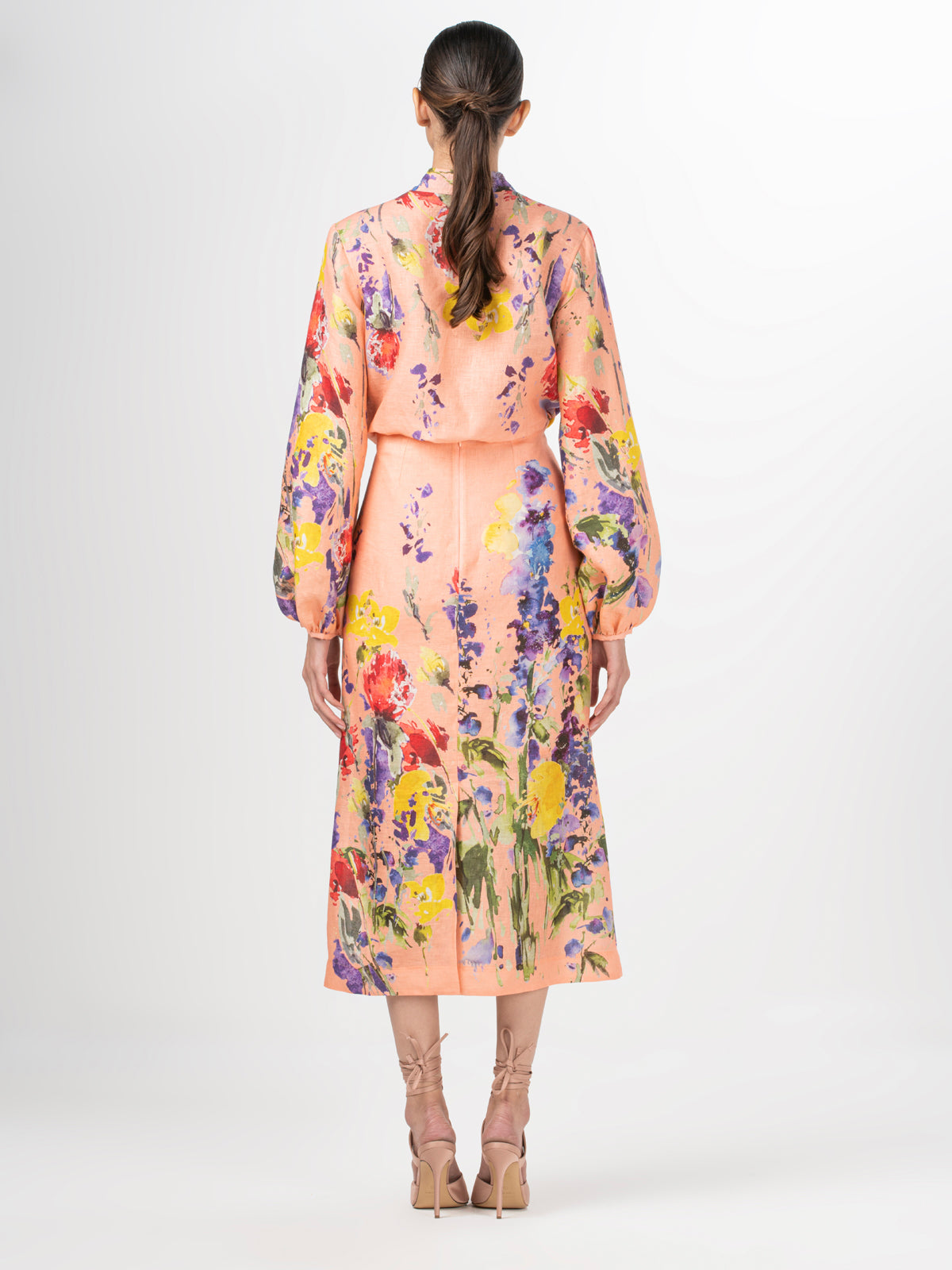 A high-waisted midi Atira Skirt Apricot Spring Garden with a multicolor floral print.