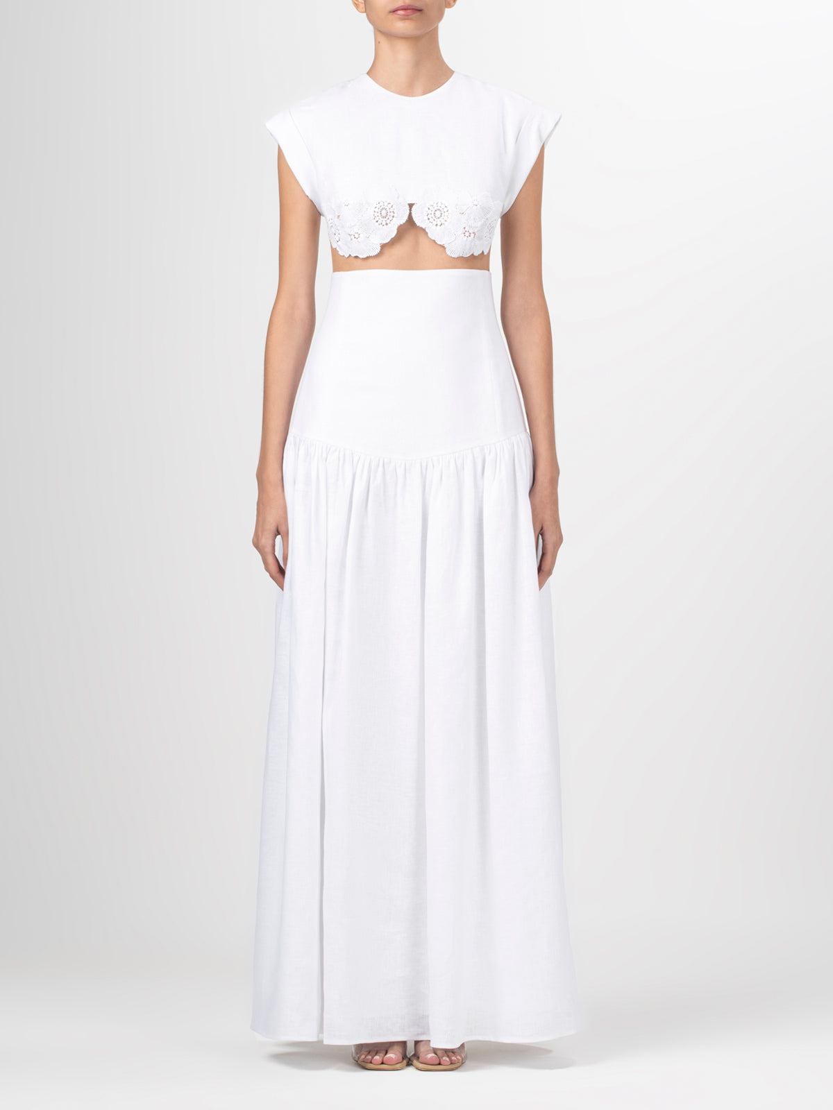 A Hanane Dress White with lace trim and a fitted silhouette.