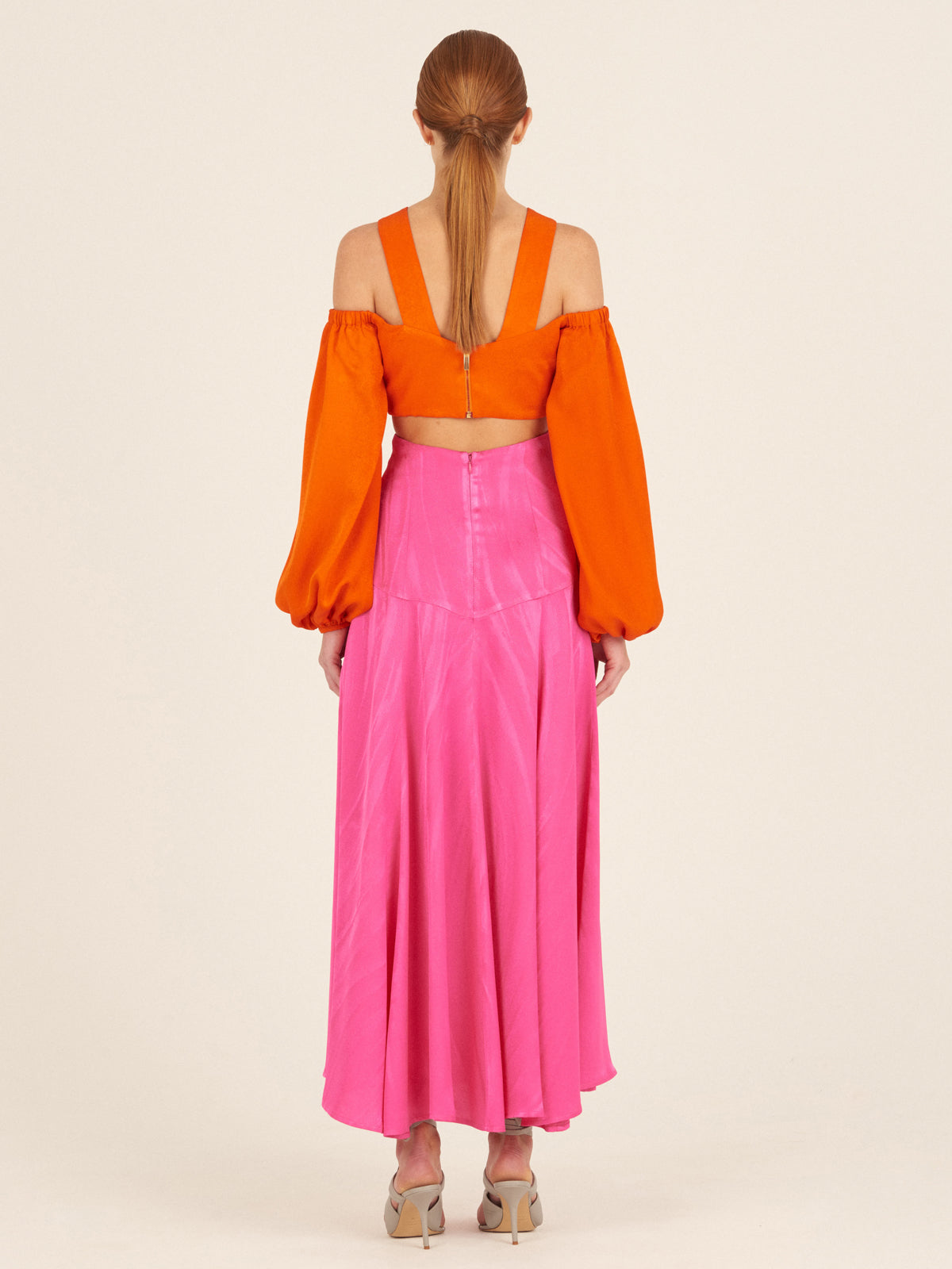 Carole Top Bright Orange off-the-shoulder crop top with billowing sleeves and a cross-body strap design, isolated on a white background.