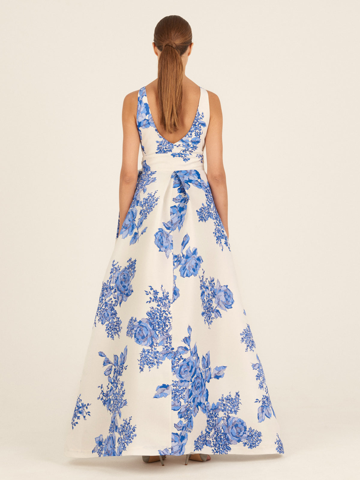 White sleeveless Logan Dress Blue Rose Motif with a bow on the shoulder, displayed against a white background.