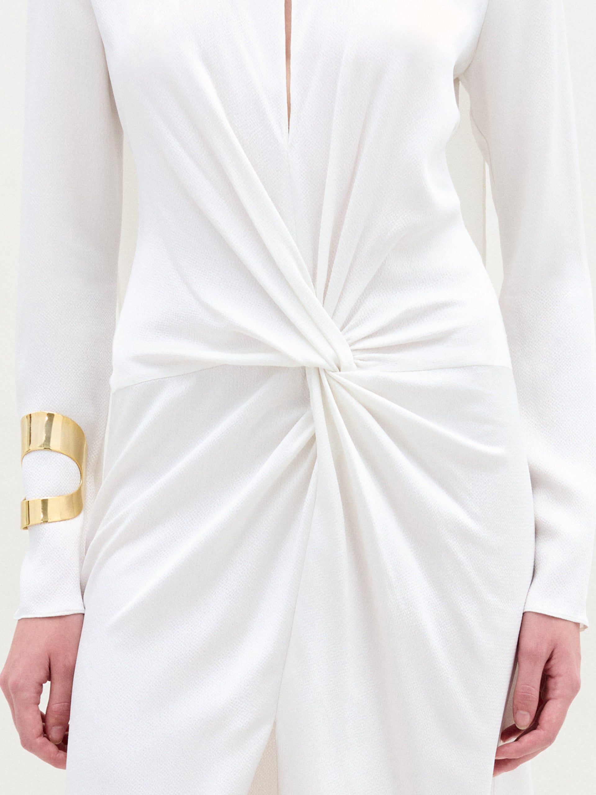 A person stands against a plain background wearing the Sue Dress in color White