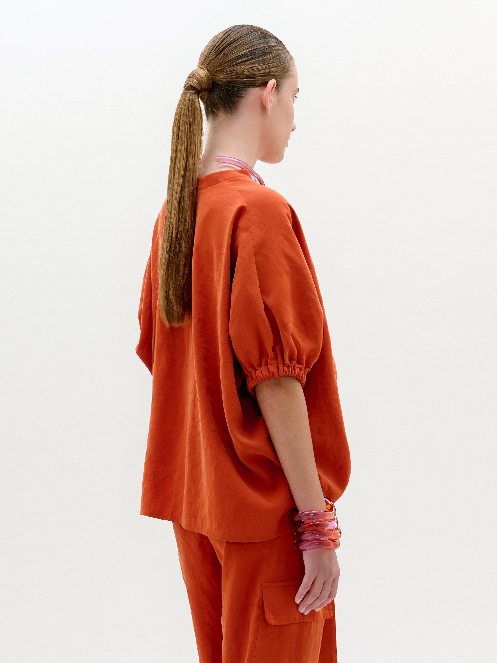 Person wearing an orange outfit with a plain background