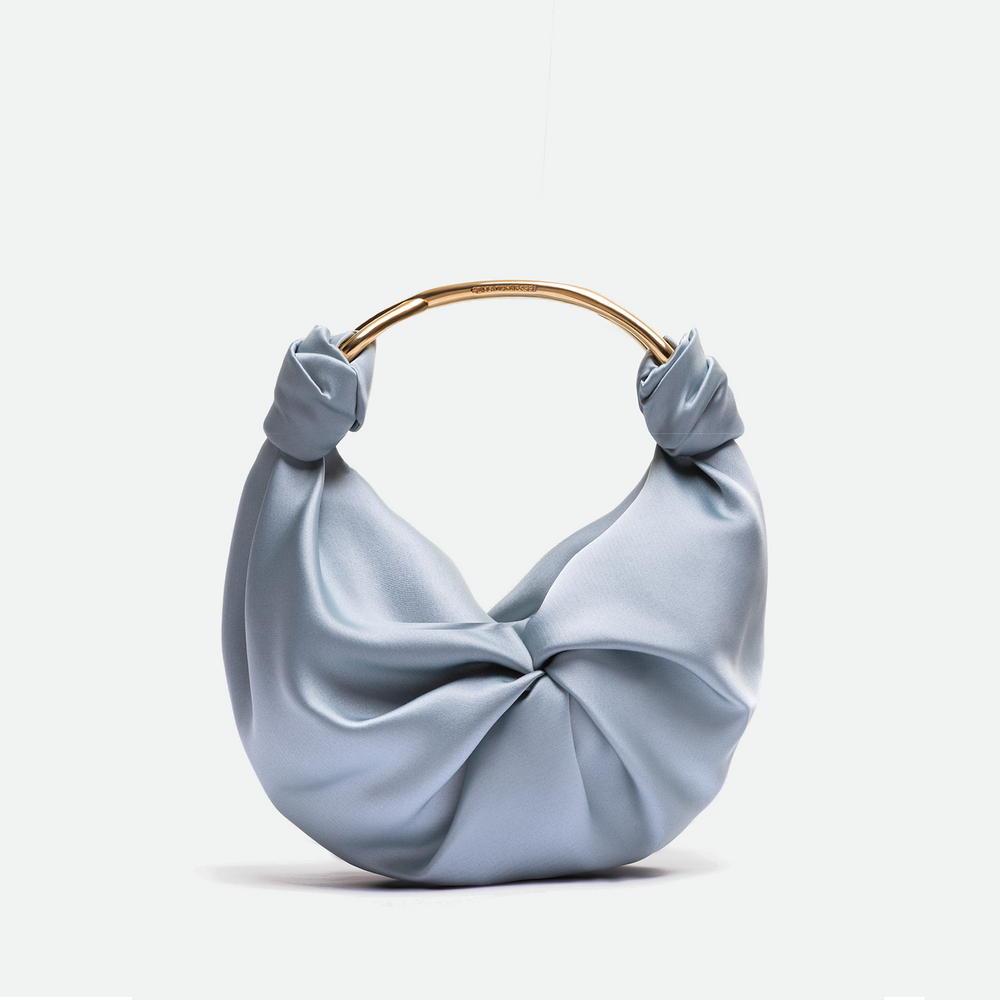 Light blue handbag with a gold handle on a white background