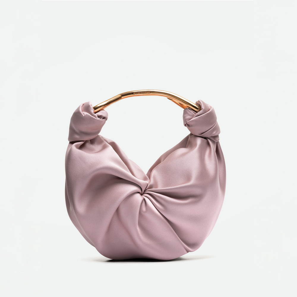The Sofia Bag (Small) is a light pink satin handbag made from luxurious Italian fabric, featuring a round gold-toned handle and a knotted front design, shown against a plain white background.