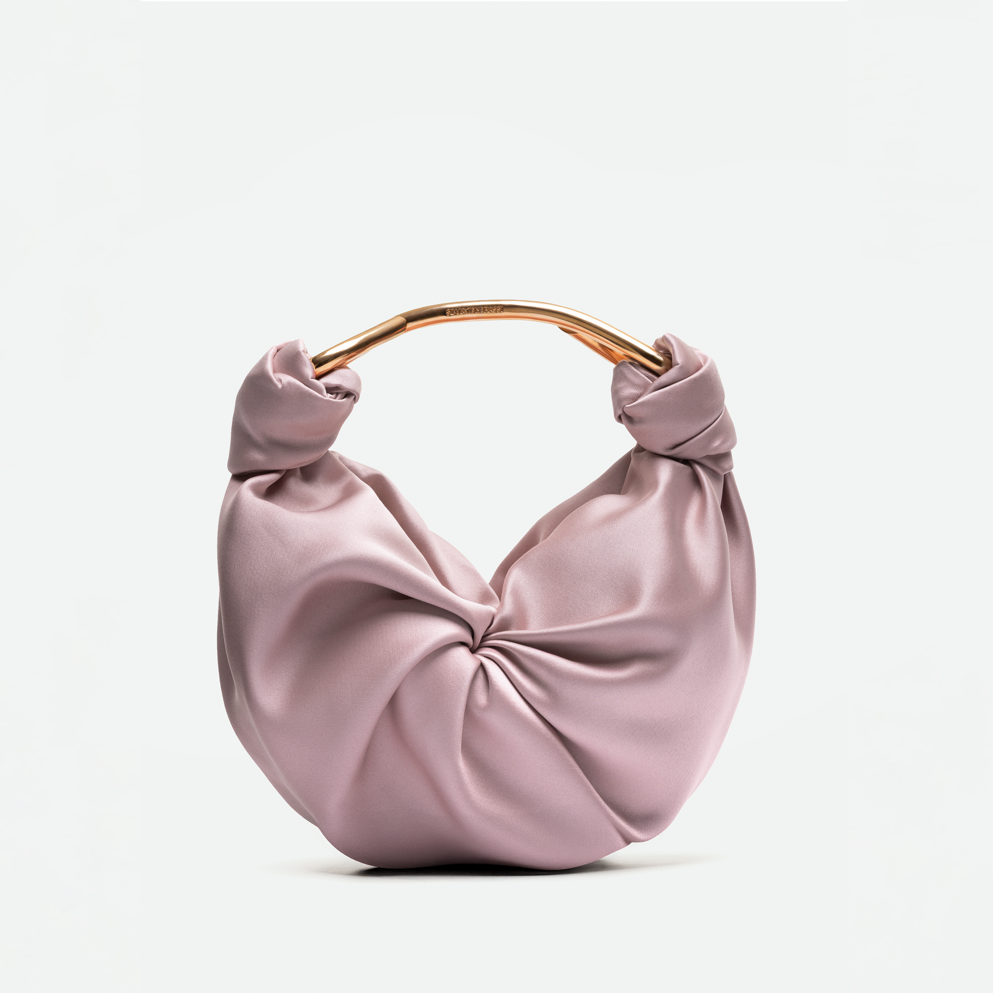 The Sofia Bag (Small) is a light pink satin handbag made from luxurious Italian fabric, featuring a round gold-toned handle and a knotted front design, shown against a plain white background.