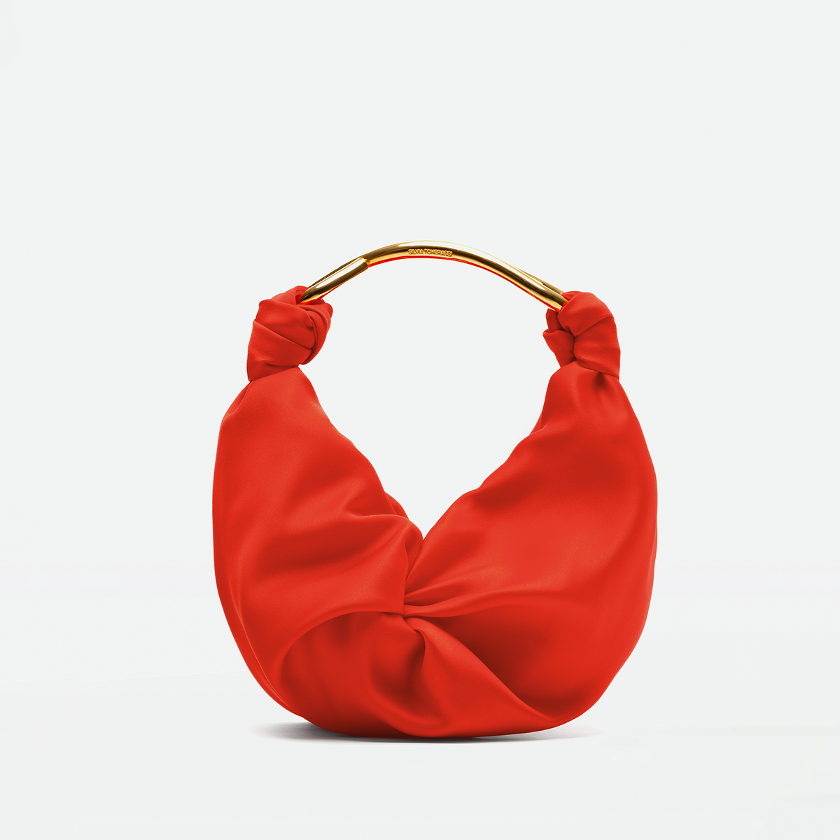 Red Sofia Bag (Small) with a crescent shape, a gold metal handle, and knotted ends.