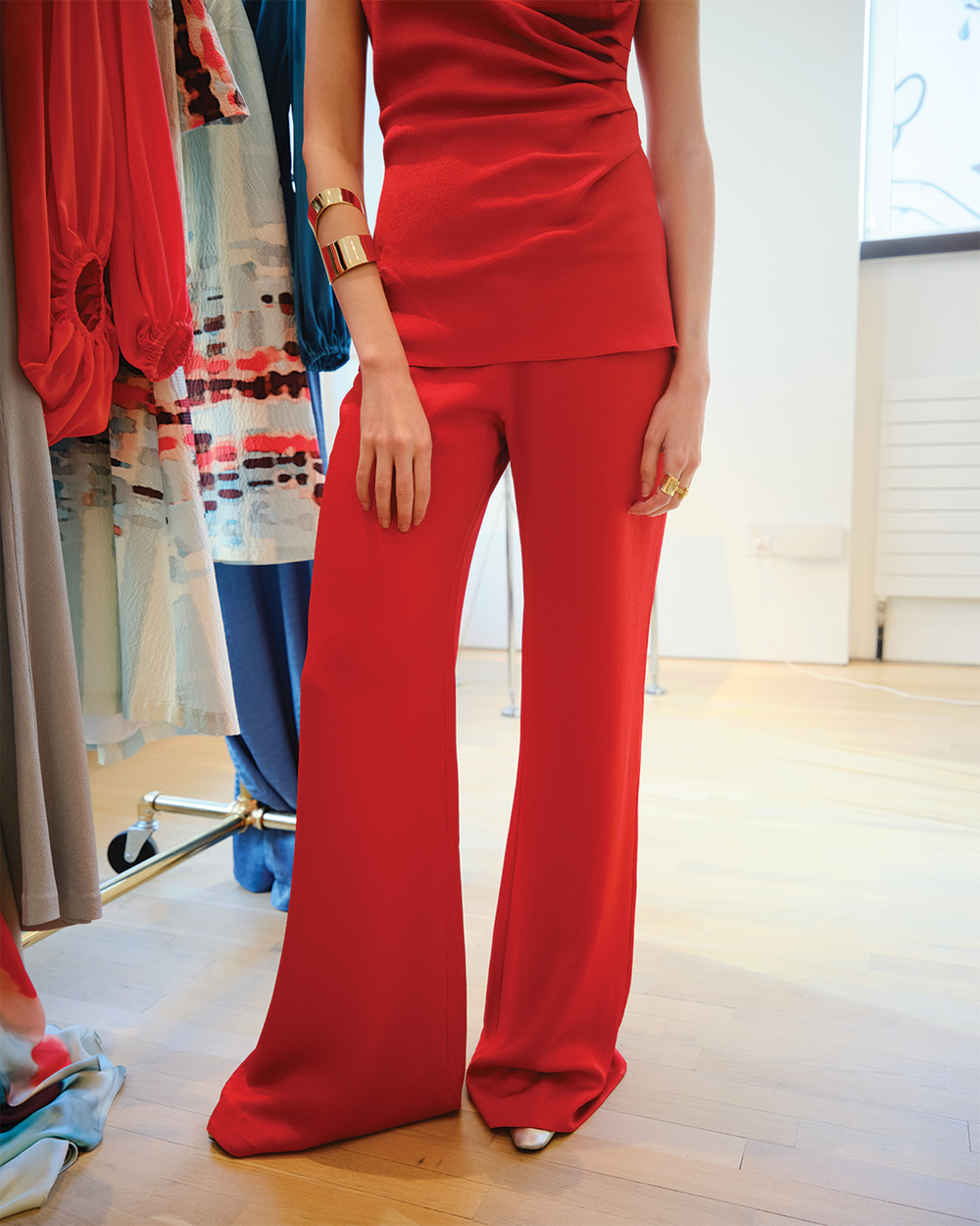 Person wearing a red outfit with a blurred background of clothing racks.