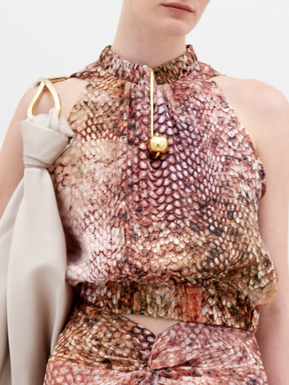 A person stands against a plain background wearing the Stefano Blouse in animal print