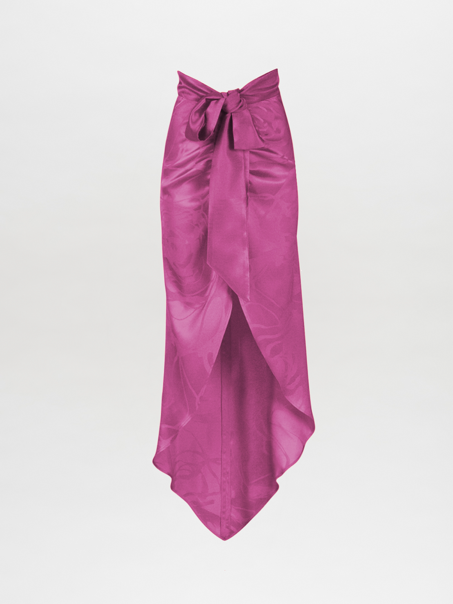 The Tara Skirt Magenta Orchid Jacquard is a long floral jacquard wrap skirt in magenta, featuring a front overlap, waist bow, and asymmetric hem for a flowing, elegant nighttime look.