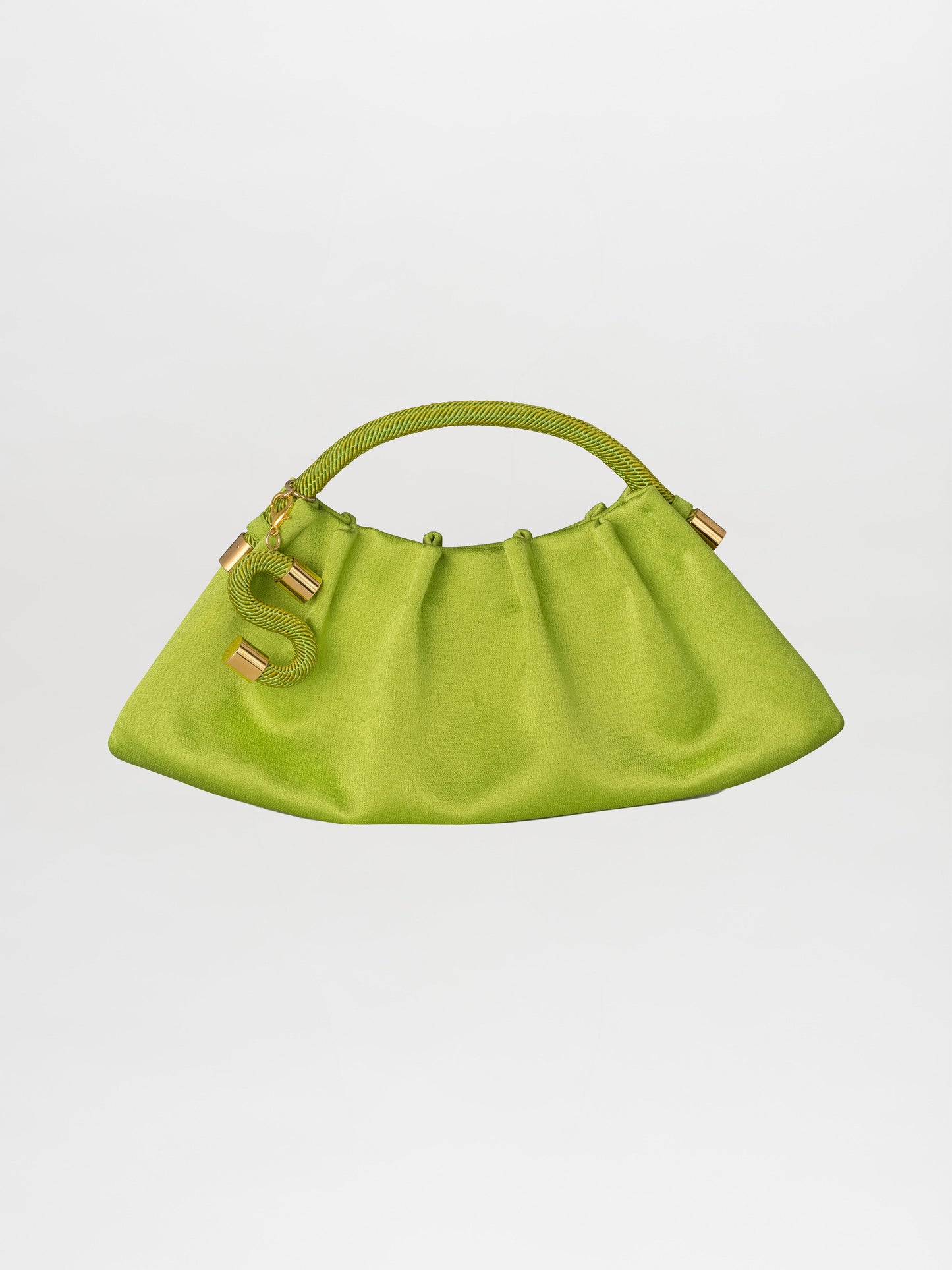 Introducing the Trapezius Clutch Lime: a pleated clutch crafted from crepe fabric, showcasing a vibrant green color and an organic, unique shape with a curved handle. It is elegantly adorned with gold accents and features a stylish S-shaped charm.