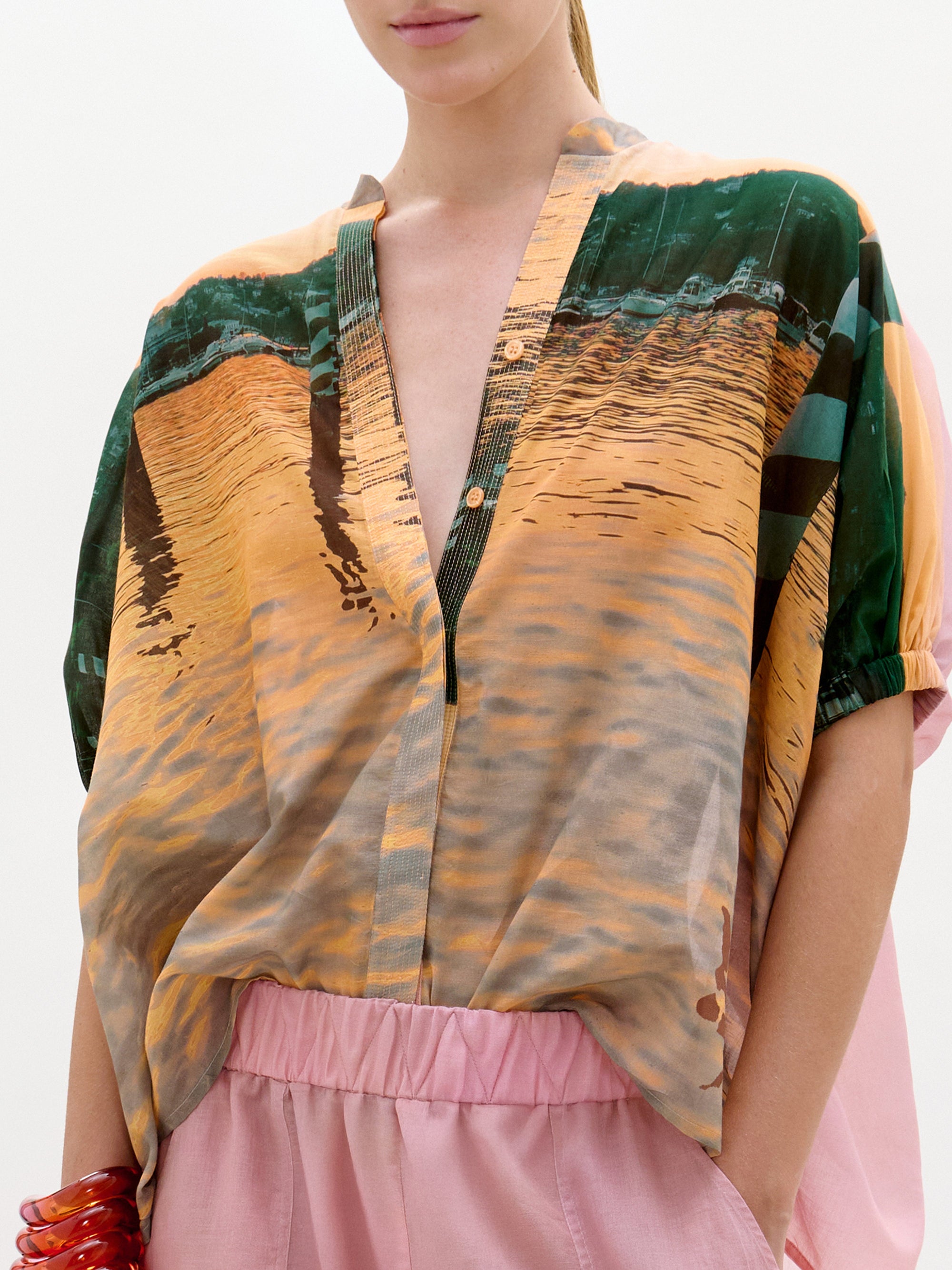 Person wearing a patterned top with a neutral background